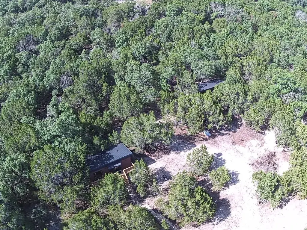 Two casitas tucked into the wooded hillside, seen from above
